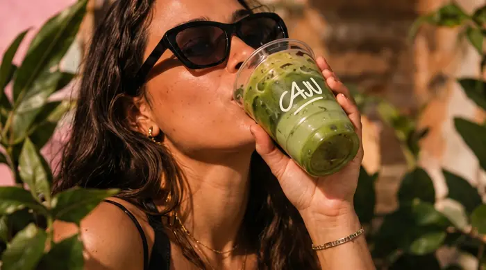 Mulher de óculos escuros tomando mate gelado