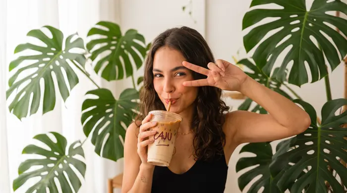 Garota fazendo sinal de paz com shake